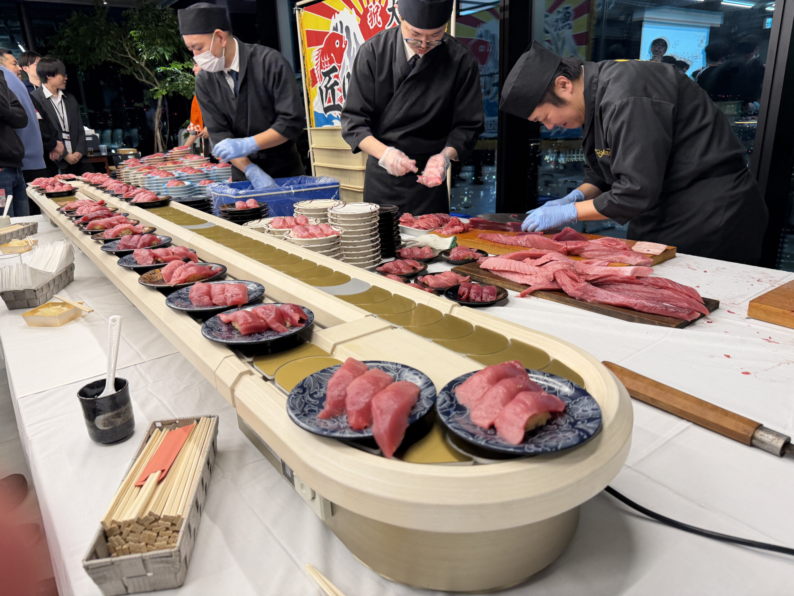 職人が捌いたマグロを回転寿司レーンで提供する様子